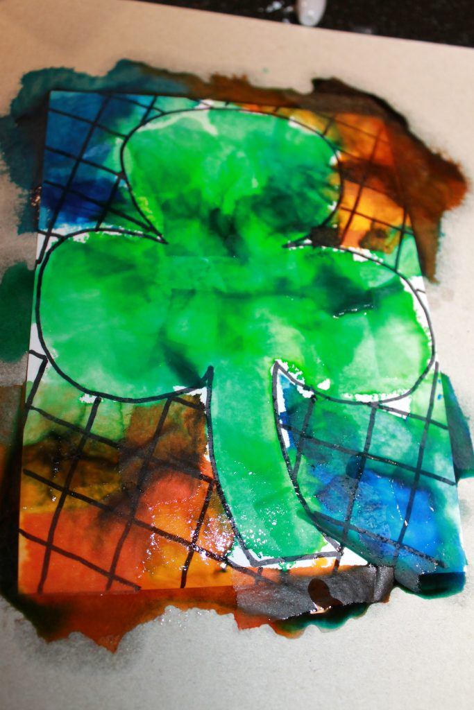 Bleeding tissue paper painted shamrocks for St. Patrick's Day. Easy arts and crafts art ideas for preschoolers and kids.