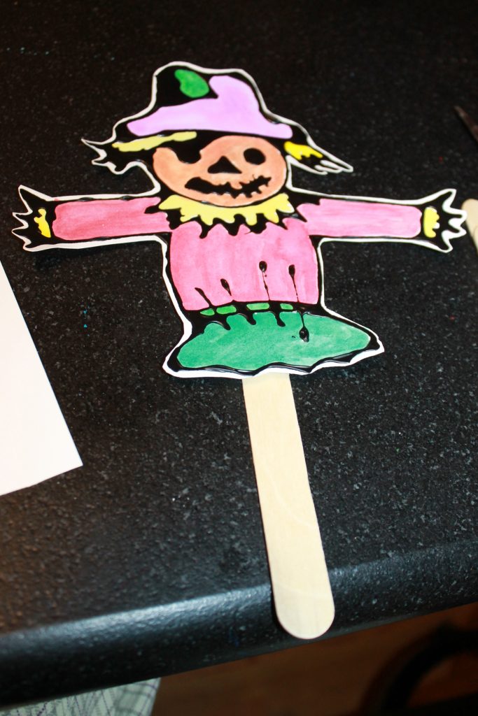 Black glue and watercolor scarecrow puppets with printable template to decorate. Fall / autumn arts and crafts for kids. Painting